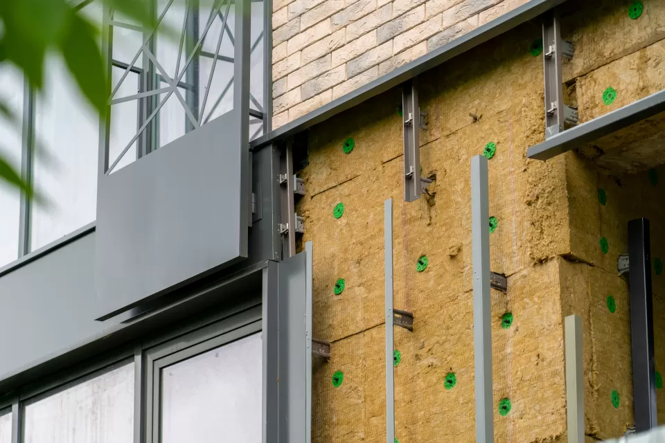 Installation of external wall thermal insulation with rock wool on Passive House residential building.